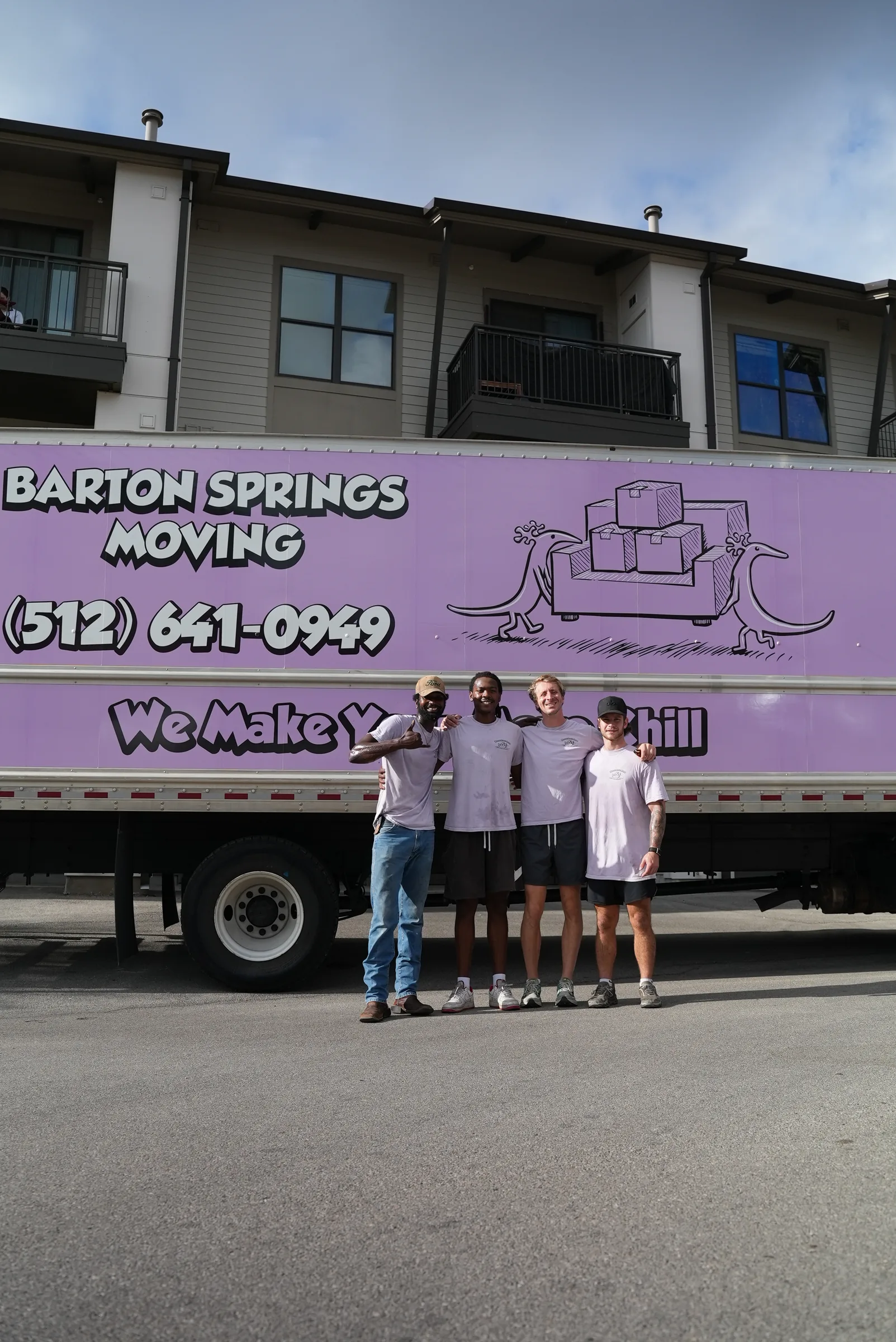 Barton Springs Moving crew standing in front of their purple moving truck